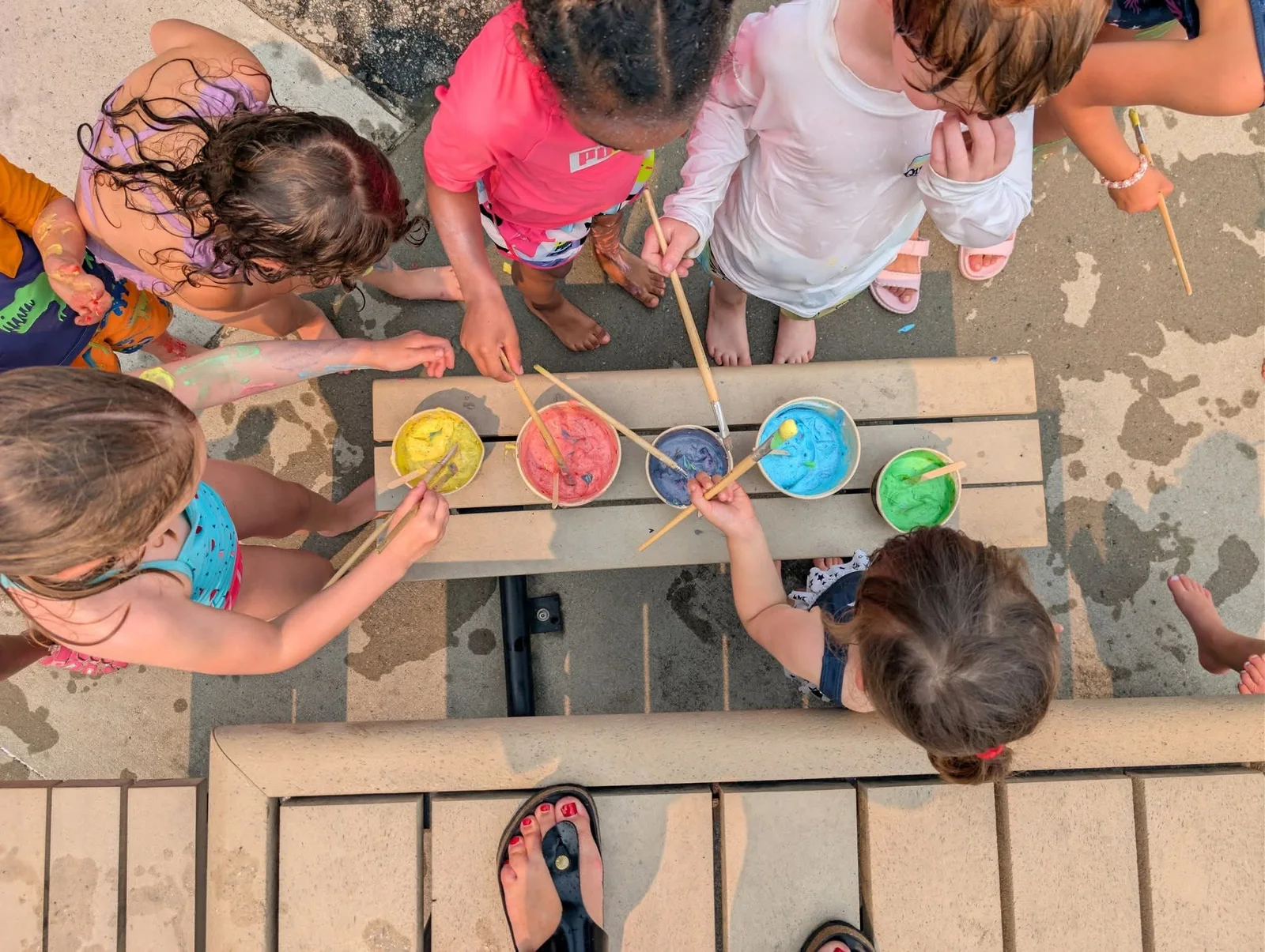 Enfants de La petite école réalisant une activité de peinture colorée à l’extérieur