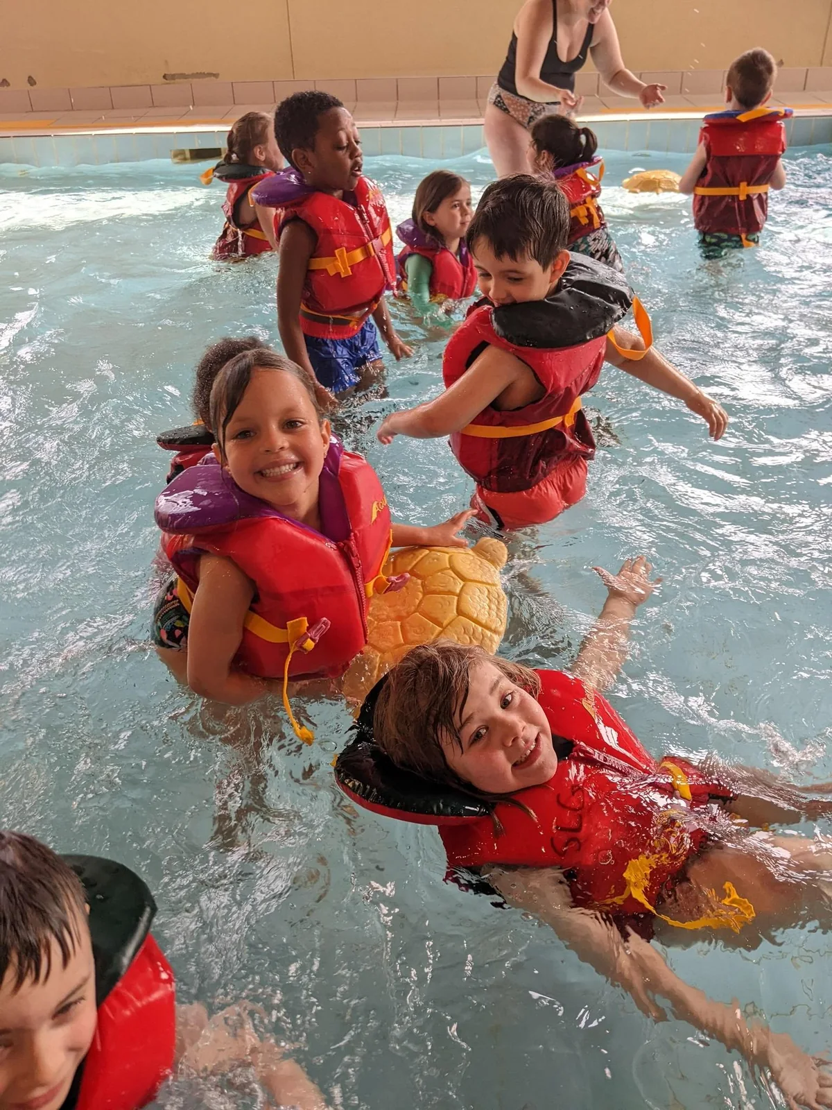 Enfants de La petite école participant à une activité aquatique avec des vestes de flottaison