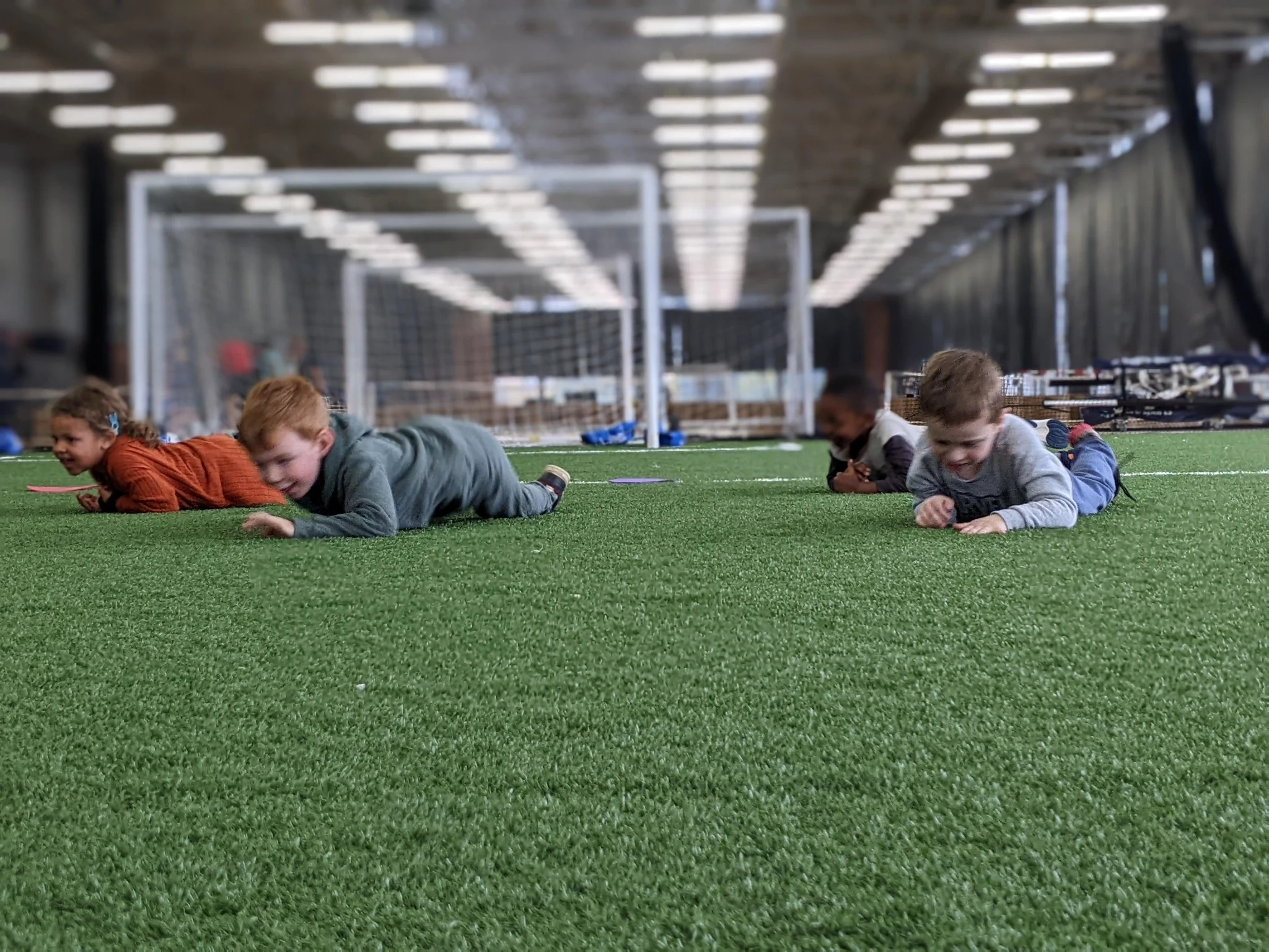 Enfants de La petite école participant à une activité sportive sur gazon intérieur
