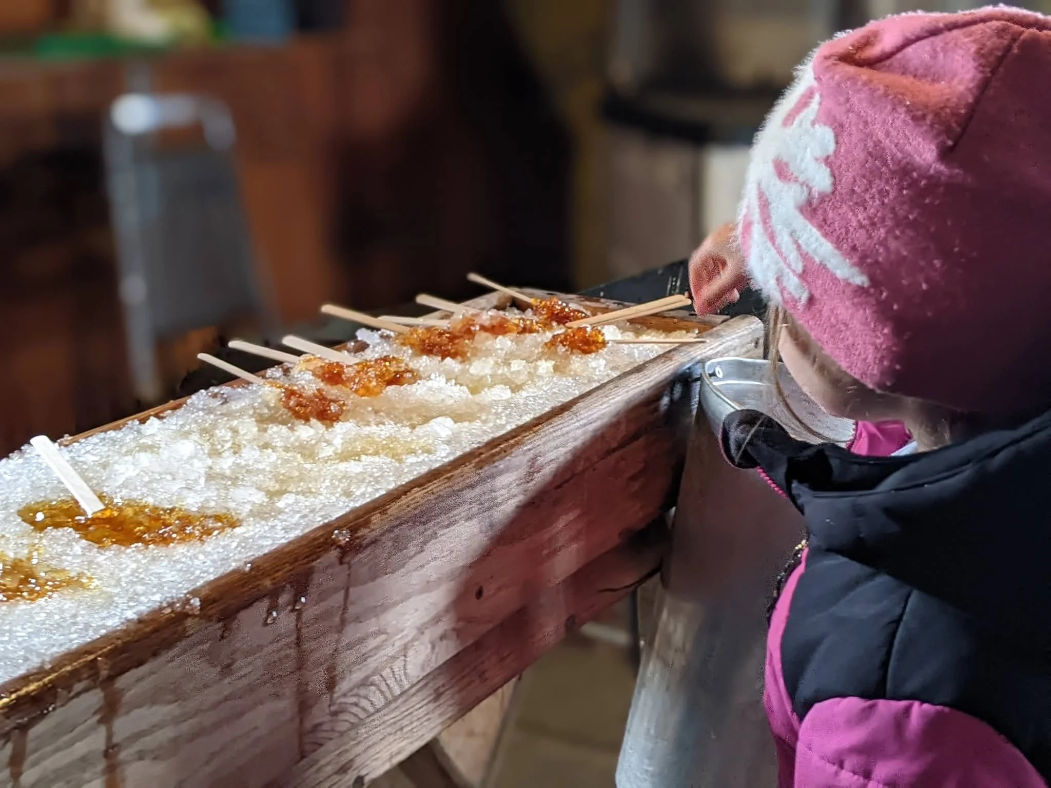 Enfant participant à une activité de tire d’érable sur neige