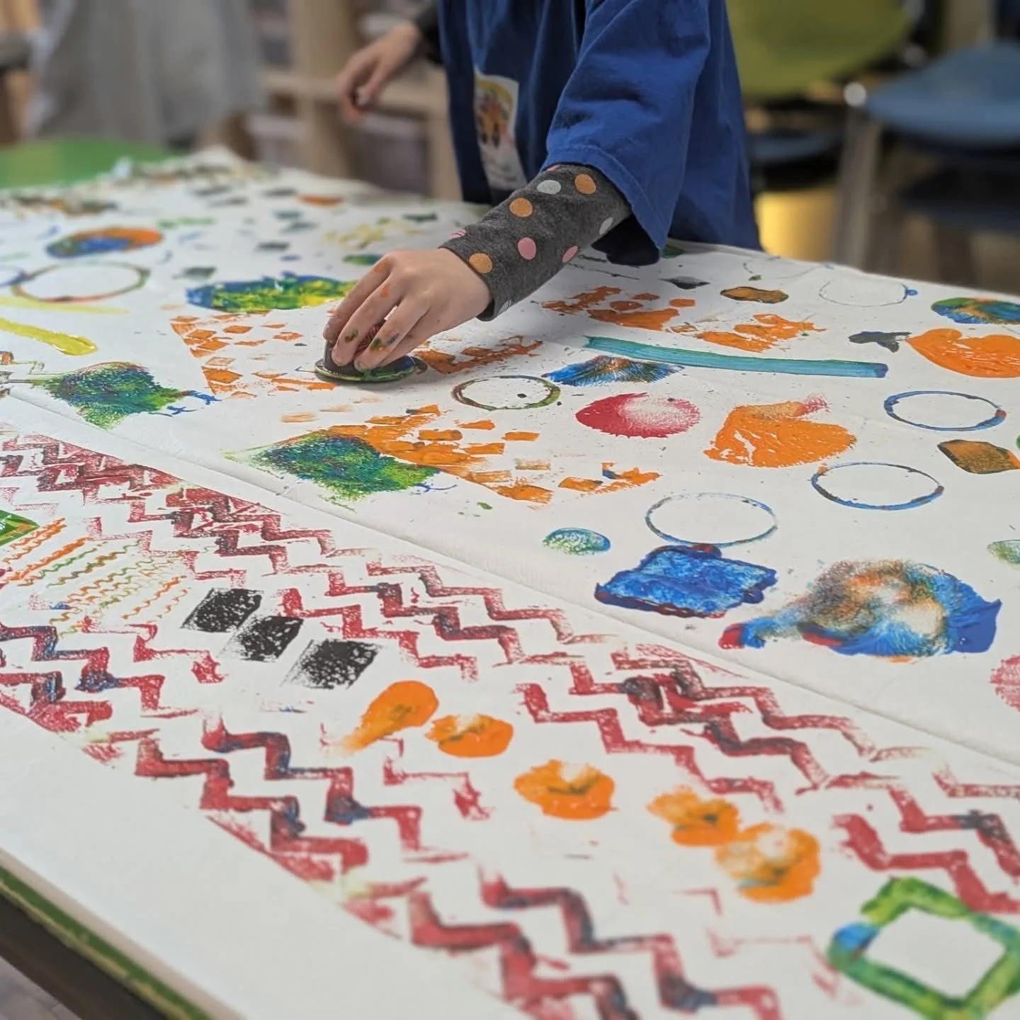 Enfant de 4 ou 5 ans créant des motifs colorés pendant un atelier d’arts plastiques à Aylmer