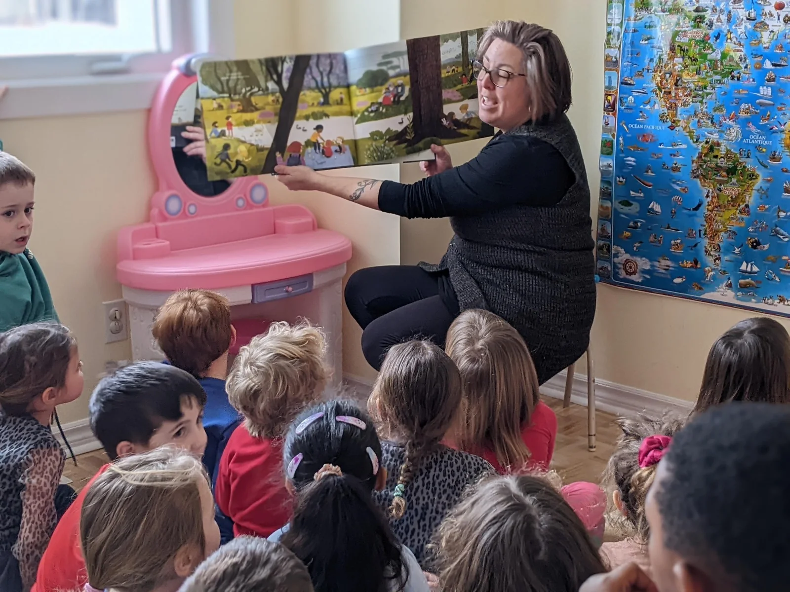 Éducatrice lisant une histoire à un groupe d’enfants de La petite école