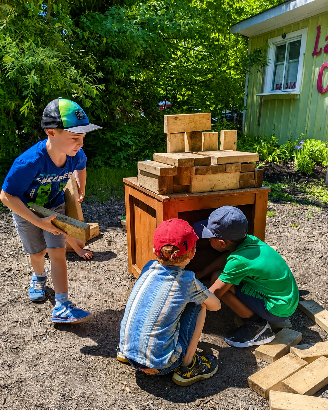 Enfants de La petite école construisant ensemble avec des blocs de bois dans la cour extérieure