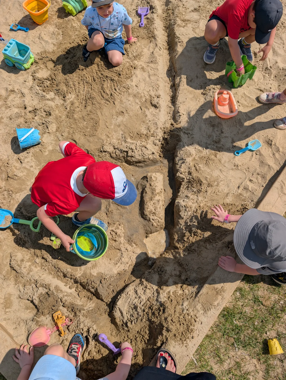 Enfants jouant librement dans un carré de sable